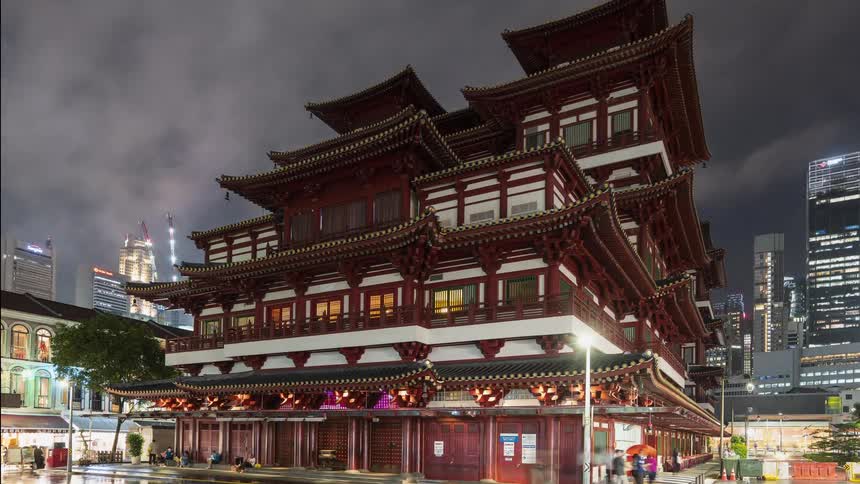 Pedestrians and vehicles move around a traditional Buddhist temple