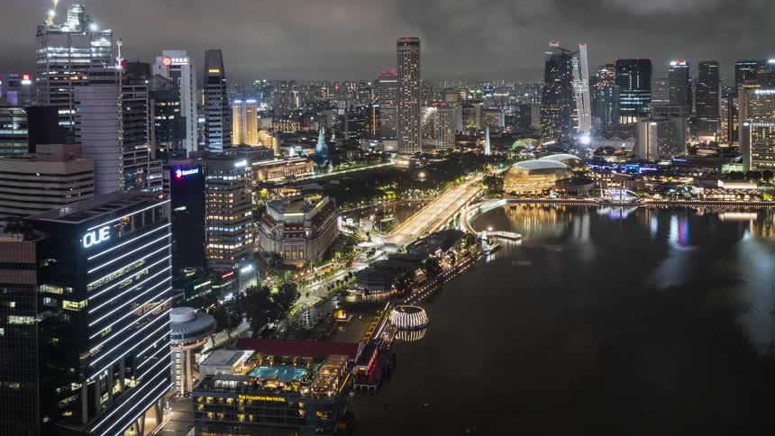 A time lapse of a city at night with traffic traveling the roads and a waterway in Singapore