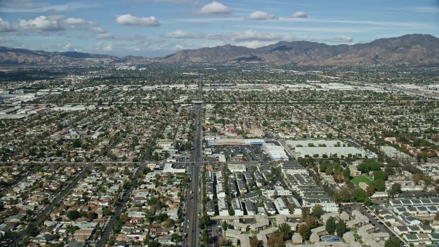 A stunning aerial view footage of Pacoima and San Fernando Valleys residential neighborhoods during a partly cloudy day