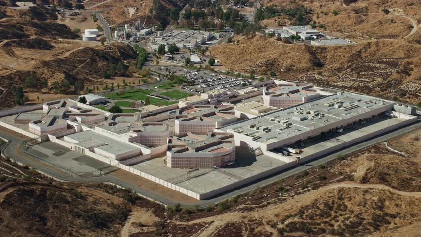 Aerial footage orbiting a supermax correctional facility in Valencia CA on a partly cloudy day