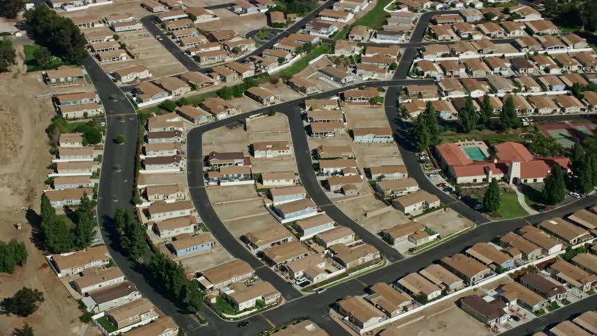  aerial footage of a luxurious manufactured home community in Sylmars affluent neighborhood featuring cul-de-sacs and swimming pools against the backdrop of partly cloudy skies