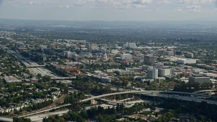 Aerial footage of Pasadena City Hall and office buildings across the 134 freeway as traffic travels during the day in Southern California
