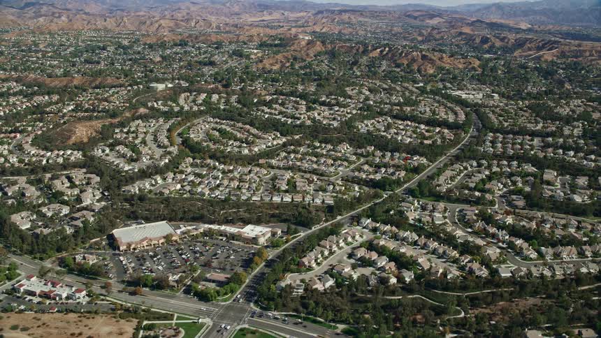 Flying over a residential area of tract homes in Valencia California on a partly cloudy day