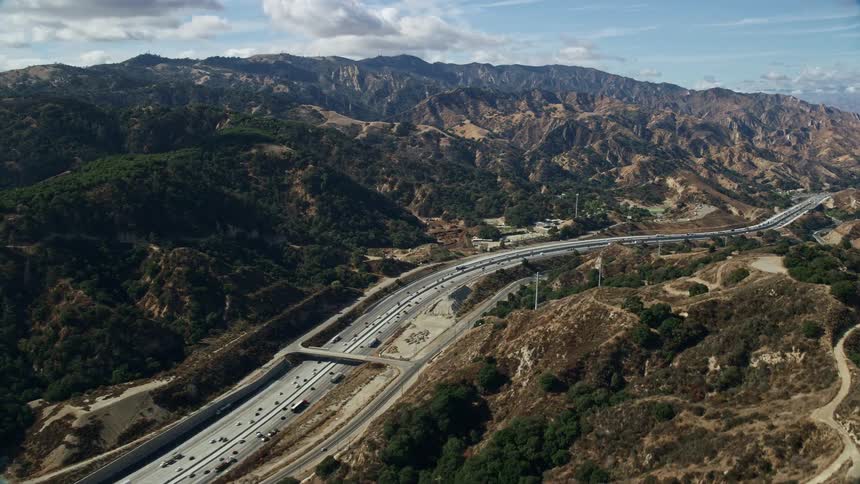 Aerial footage of light traffic on I-5 passing through Santa Clarita California