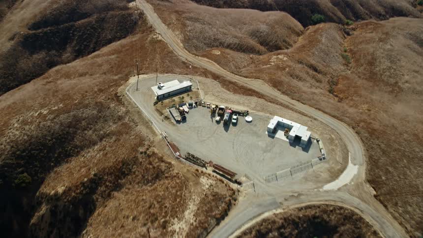 Aerial footage of a storage facility in the hills near dirt trails at Chino Hills State Park in California