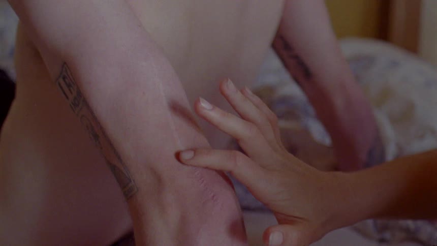 A woman runs her fingers down the back of a mans upper arm