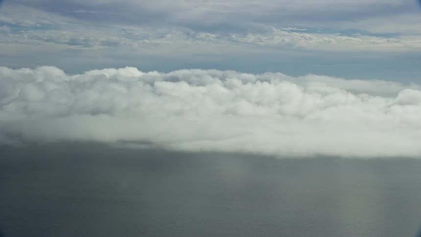 Aerial footage of cloudy skies over the Pacific Ocean in Southern California during the summer season