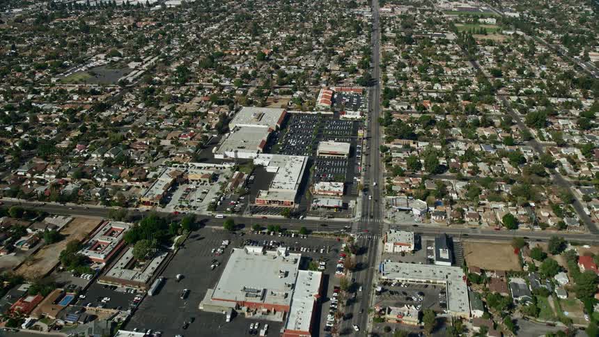 Aerial shot of shopping centers and parking lots in Sylmar California on a partly cloudy day