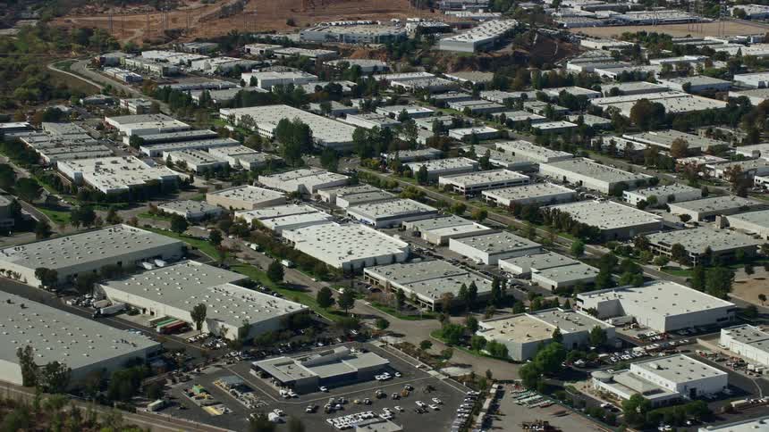 Aerial footage of office buildings and warehouses in Valencia California on a partly cloudy day