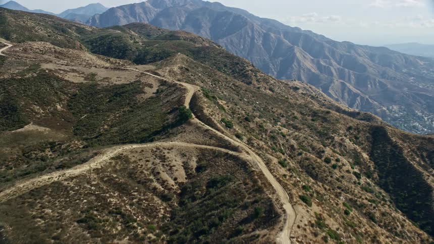  aerial footage of canyon trails in Sunland-Tujunga California showcasing mountain ridges with trails and more mountains visible in the distance