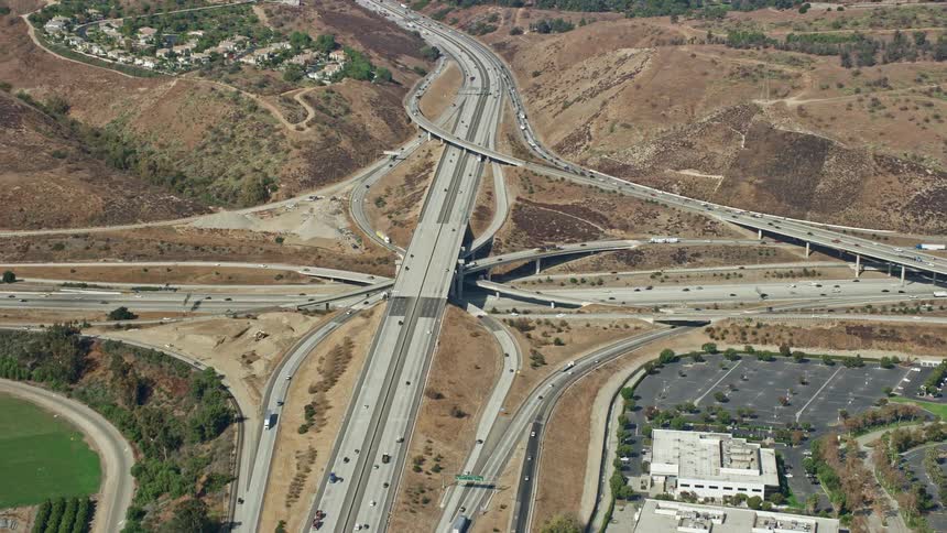 An epic aerial view of the I-10 and Hwy 57 and Hwy 71 interchange in Pomona Los Angeles County CA with light traffic flowing on sunny day during spring or summer