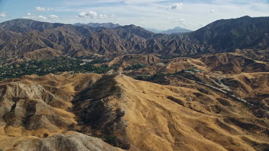 A breathtaking aerial view flying over Canyon Country and houses in Southern California during the day