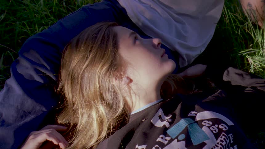 A woman laying her head on a mans leg as they are on the ground