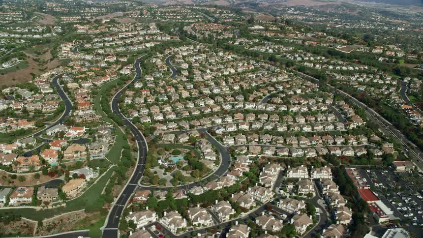Aerial footage of Mansions and tract homes lined up in the suburbs of Laguna Niguel California shot during a partly cloudy day