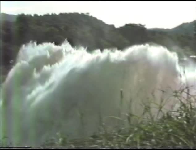 Water gushes from an aqueduct outside down a hill in nature