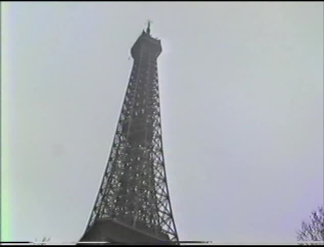Shot of the eiffel tower from bottom panning to the top of the tower with a gray sky in the back ground