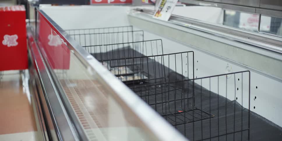 An empty freezer in a grocery store