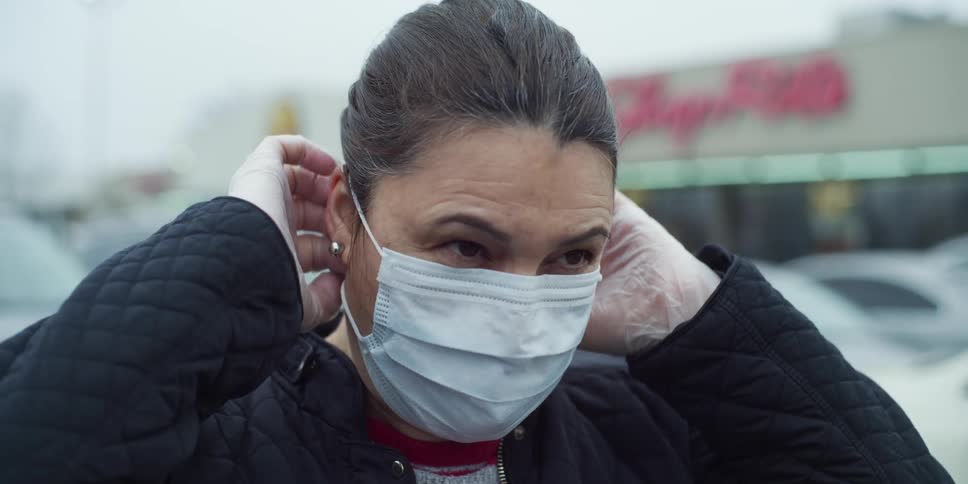A woman places a face mask on
