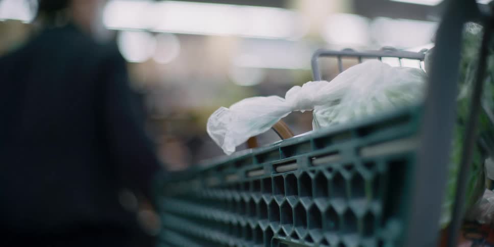 Woman wearing face mask and gloves buys groceries at the supermarket