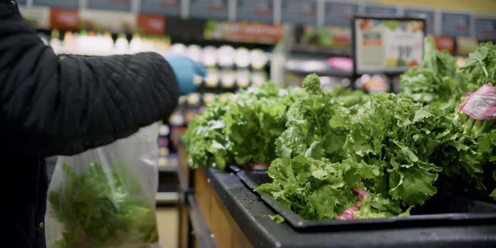 Shopper selects lettuce shakes it off and then bags it