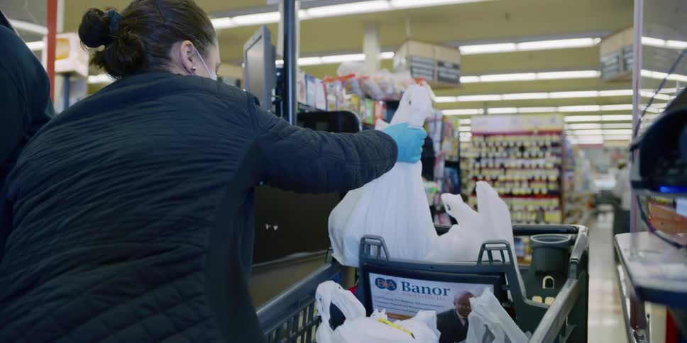 Woman wearing face mask and latex gloves buying groceries at supermarket