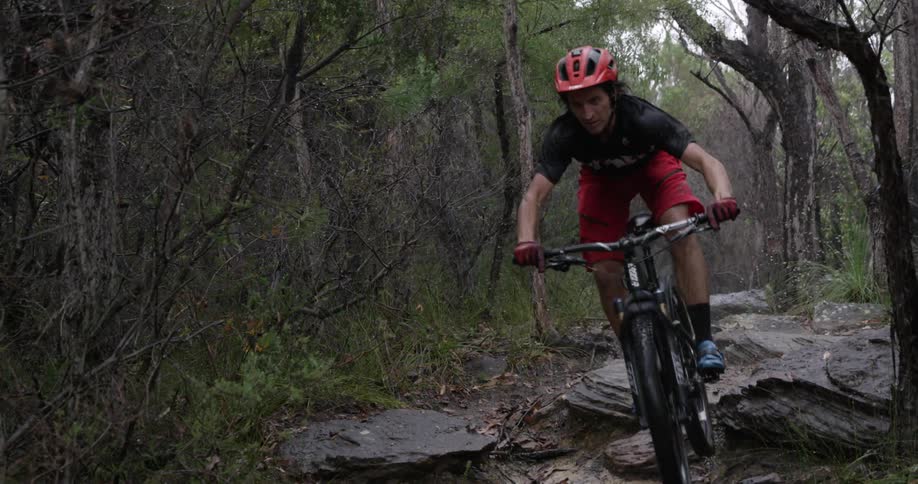 A man rides a mountain bike down a rocky trail