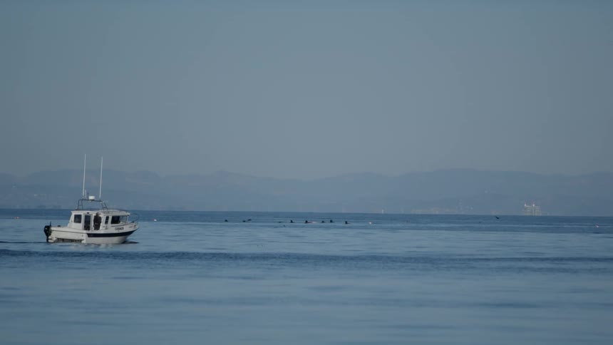 The view is of the ocean and you can see a boat in the day time