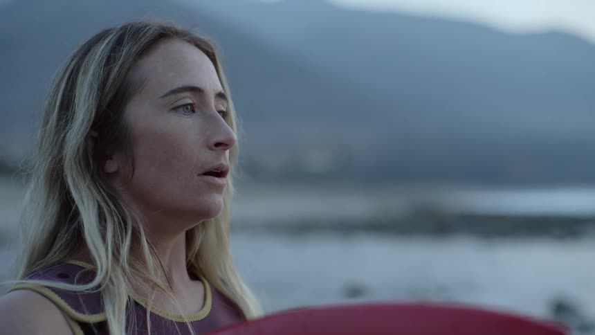 Close up of the face of a female surfer taking a breath before going into the ocean