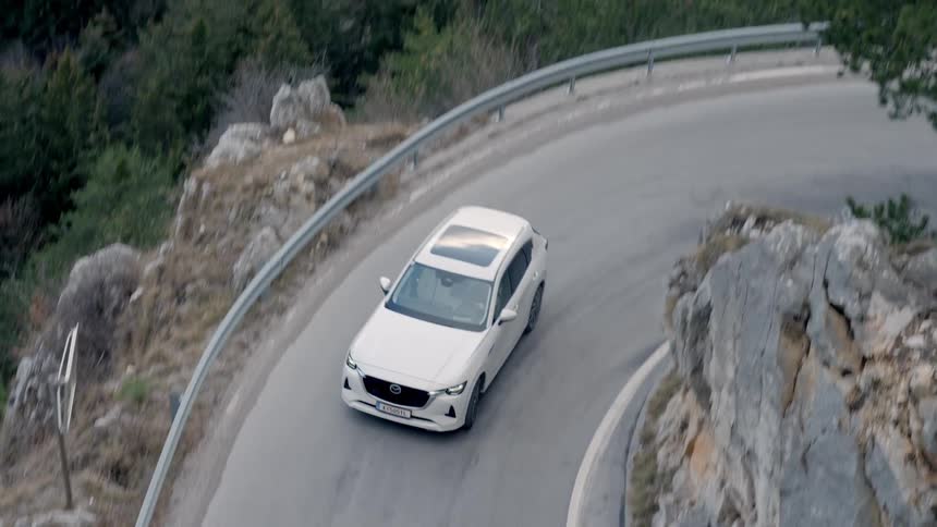 Automobiles turn around a sharp curve on a mountain road