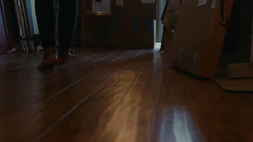 A person is walking barefoot through their house