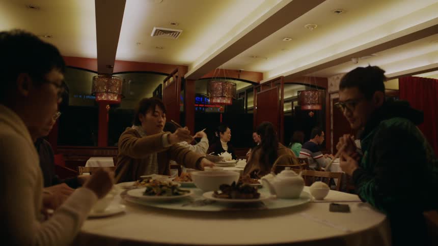 Lights coming on in a restaurant as people clap and then beginning to plate food for themselves