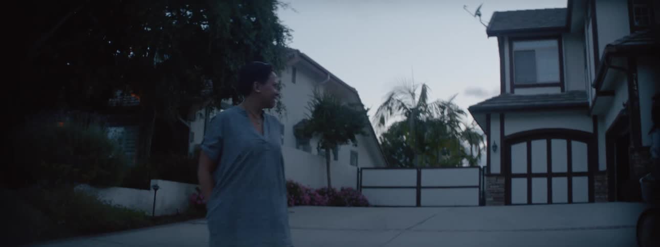 Mother looks after her daughter driving a bicycle around the neighborhood at evening