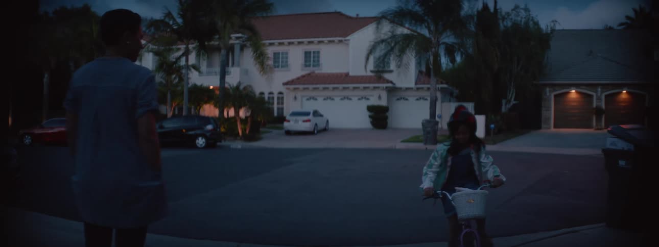 Mother surpervises her daughter while she runs around the neighborhood at evening