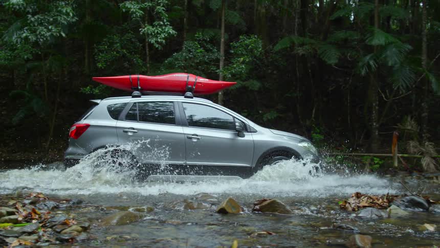 The view is of a car that is driving down the river in the day time