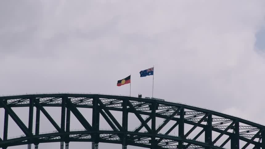 The wind is blowing the flags on the bridge