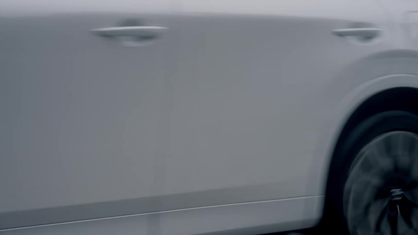 A car is driving outdoors on the street around the day time