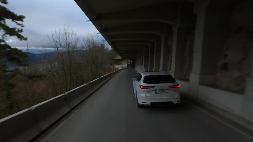 Aerial drone view tracking white car on mountain pass freeway
