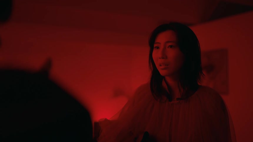 The view is of a young woman that is inside of her home at night time