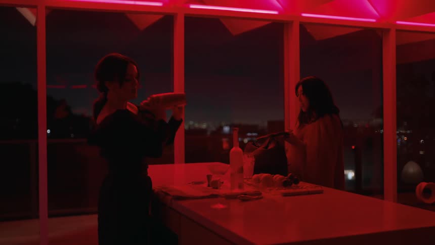 Two women are indoors and are drinking alcohol together