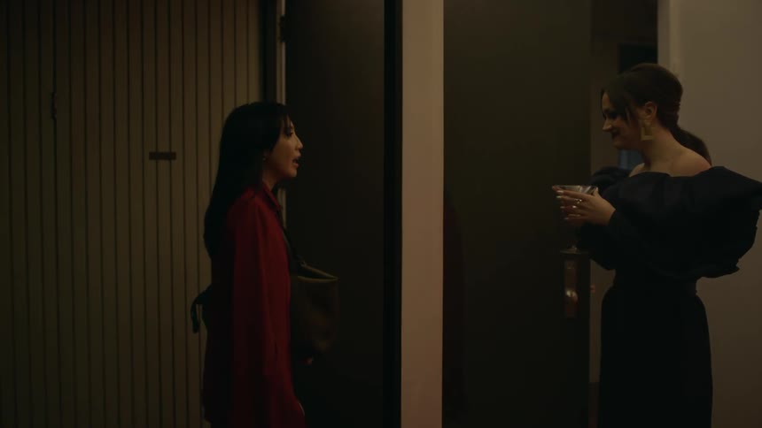 A woman raises a mask to scare her friend and then they have a laugh about it