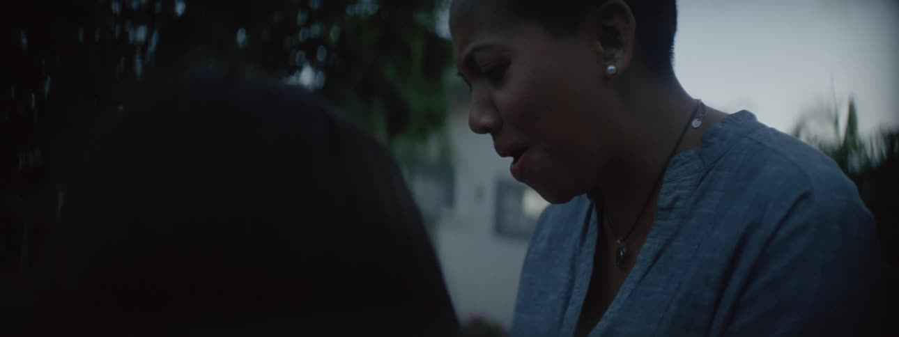 Surprised mother starts laughing while she and daughter stand outdoors in neighborhood