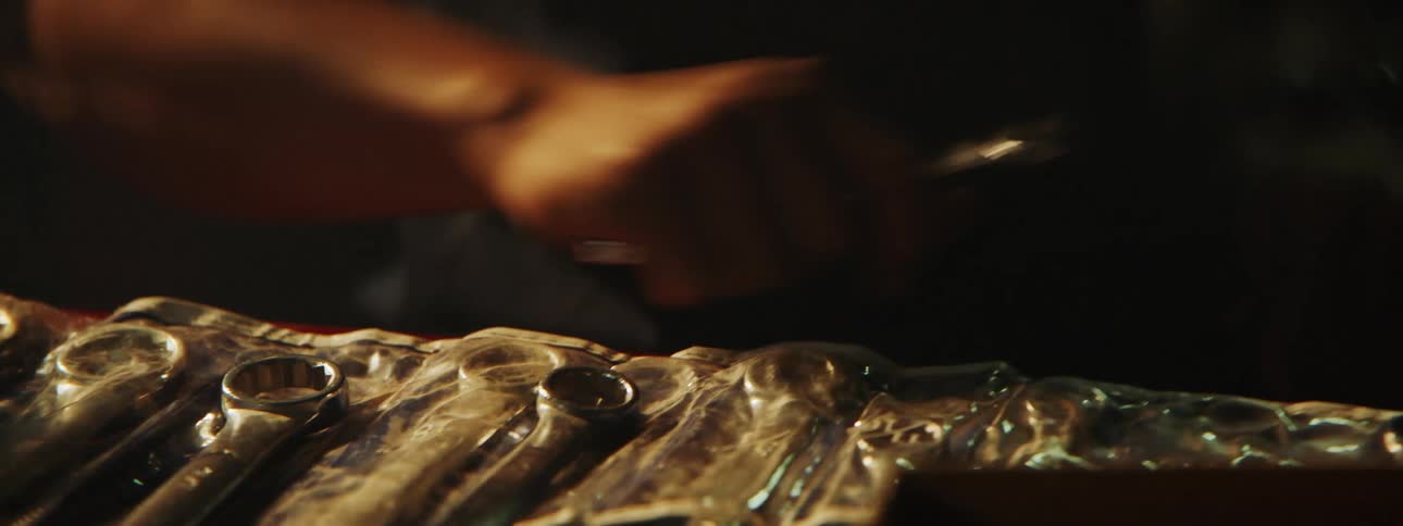 An up close of a man grabbing tools out of an organizer on a work bench