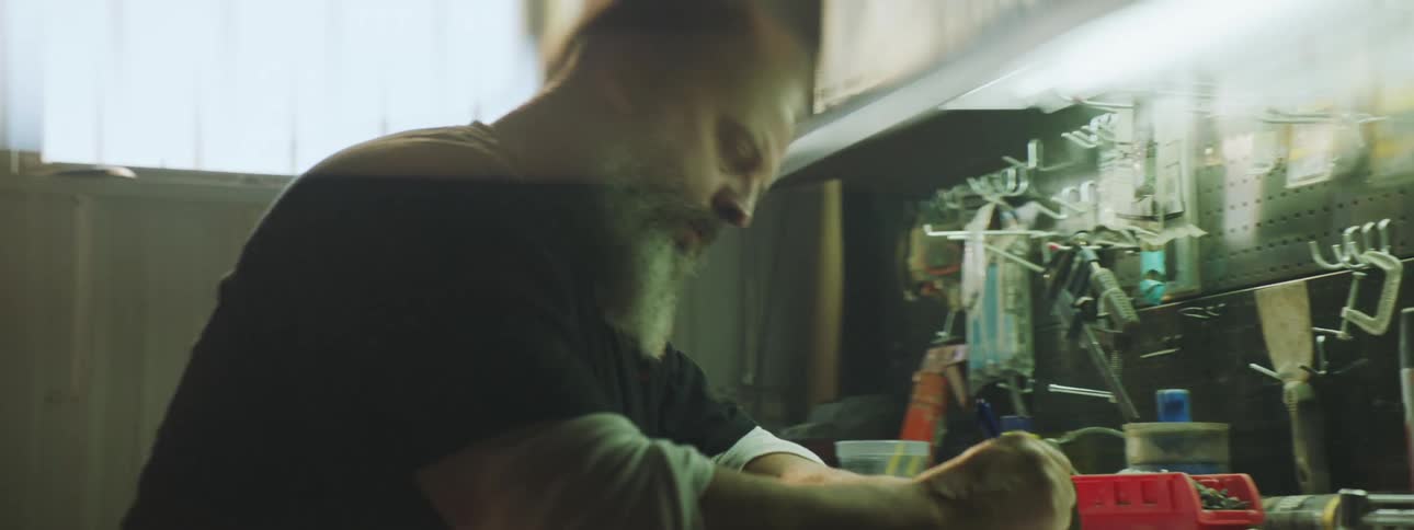 An older man is working inside of a factory in the day time