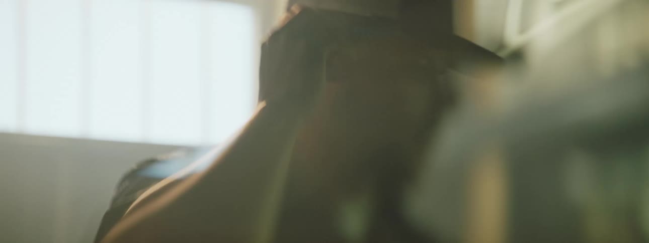 A man in a factory turning around and grabbing a pen from his ear