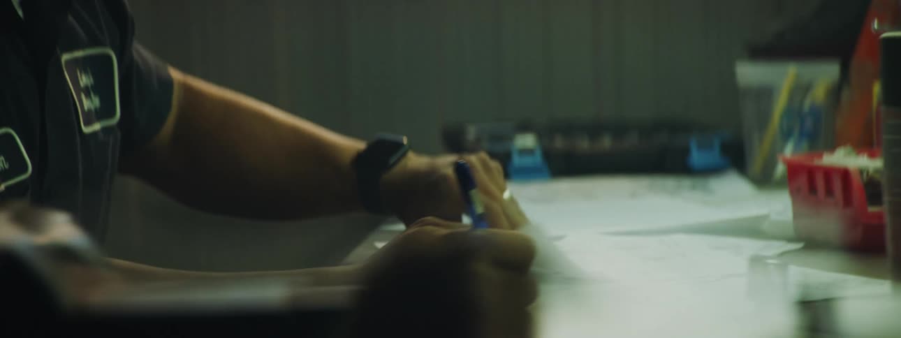 Close up of a worker taking notes over a workbench in the workshop