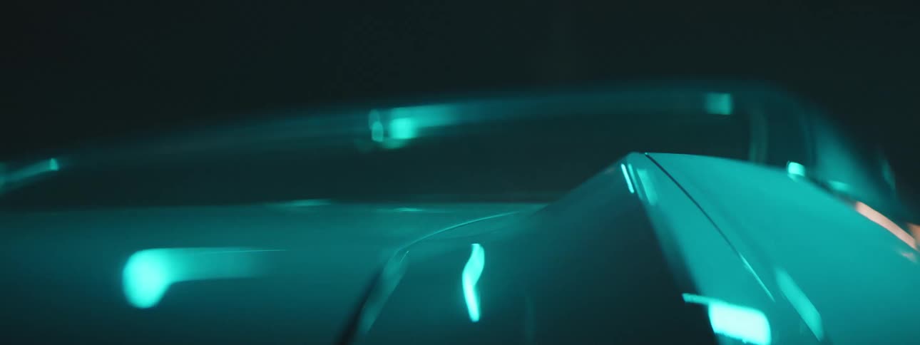 Close up of lights alternatively reflecting over the shiny body of a luxury sports car