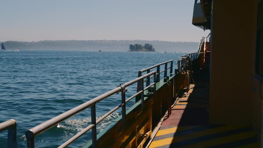 On a large boats deck the bulwark protective barrier borders the edge as it travels across the ocean waters on a clear day