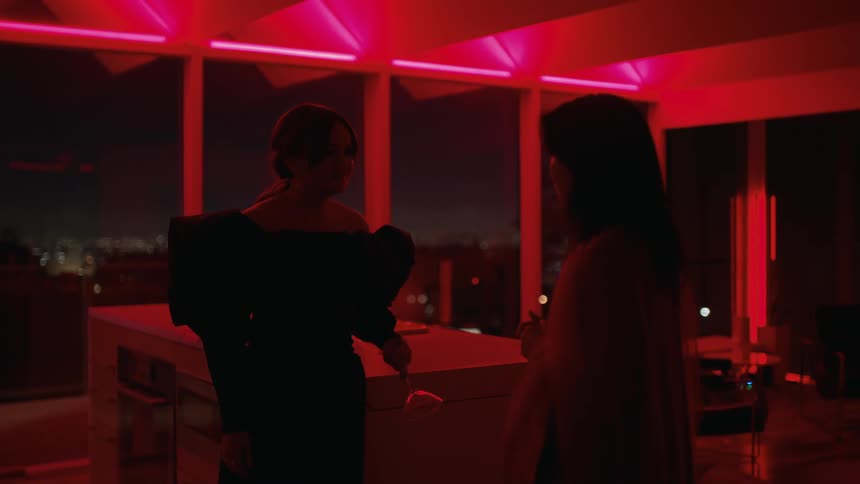 Two women are talking indoors at nightone starts to walk away and falls