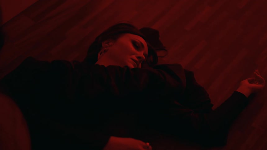 A young woman is laying on the floor and she looks upset