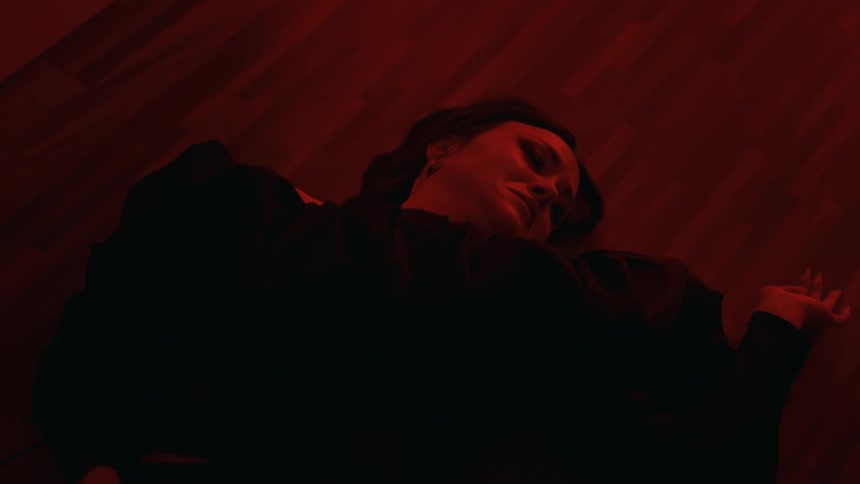 A young woman is laying on the floor and they look sad